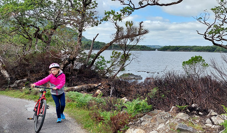 Ein Kind auf Fahrradtour im Killarney Nationalpark in Irland.