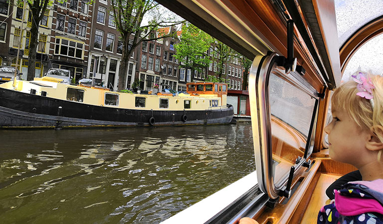 Kind schaut von einem Boot auf eine Gracht in den Niederlanden.