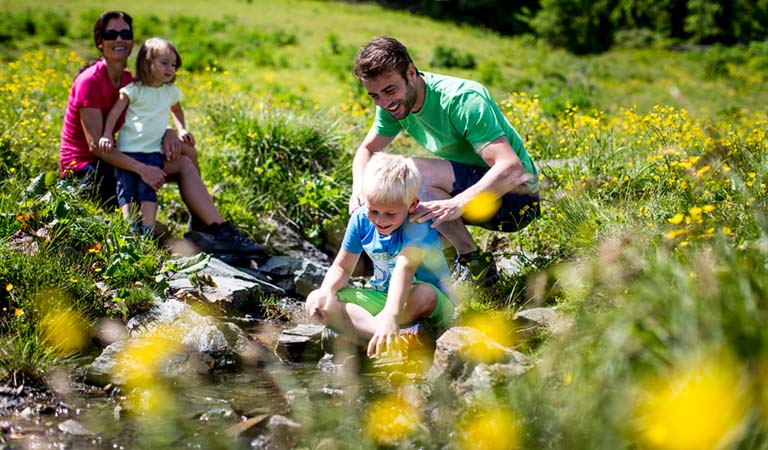 Junge spielt im Bachlauf in der Region Murau in der Steiermark in Oesterreich