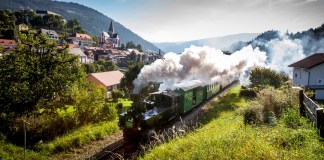 Murtalbahn mit Kindern: Familienausflug in Murau in der Steiermark Die Dampflokomotive der historischen Muralbahn fährt doch die hügelige Landschaft.