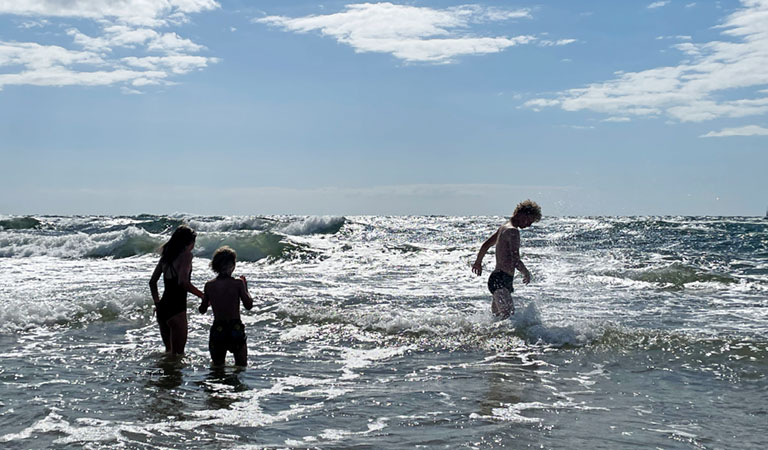 Kinder in den wilden Ostseewellen beim Baden auf der dänischen Insel Bornholm.