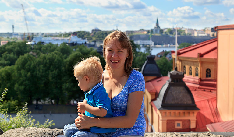 Mutter mit kleinem Sohn auf dem Arm über den Dächern von Stockholm in Schweden