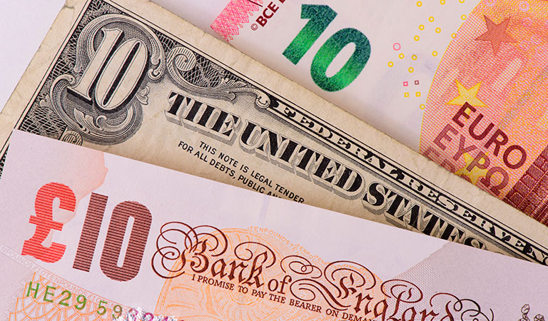 Vorm Urlaub unbedingt besorgen: Geld in der ausländischen Währung, hier Scheine vom Dollar, Britischem Pfund und Euro.