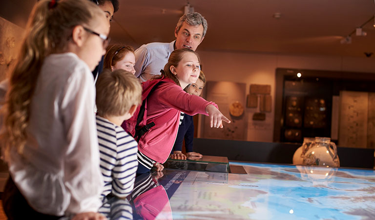Familie in einem Museum beim Betrachten eines Ausstellungsstücks.