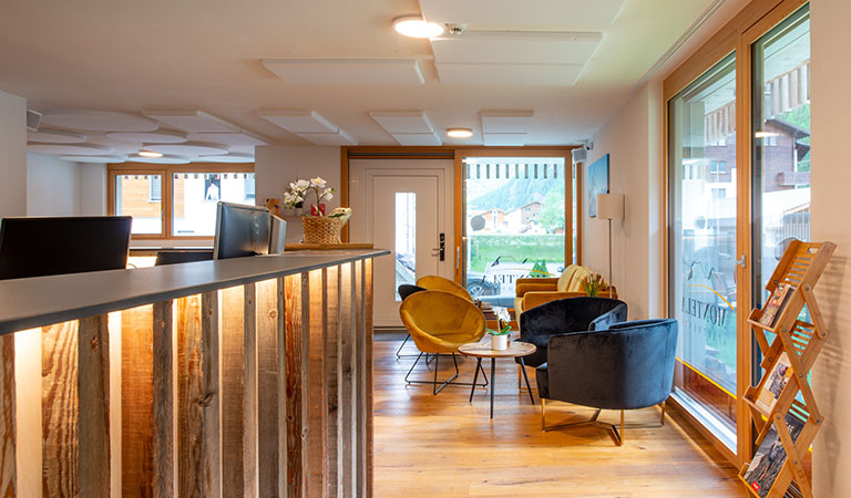 Die Rezeption im Montela Apartment-Hotel & Resort mit Empfangstresen und Besuchersesseln