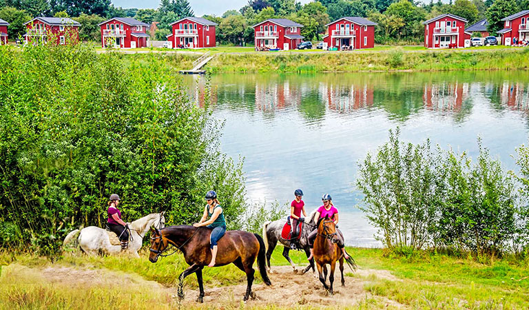 Reiter am See mit den Ferienpark Geesthof in Niedersachsen in Deutschland im Hintergrund.