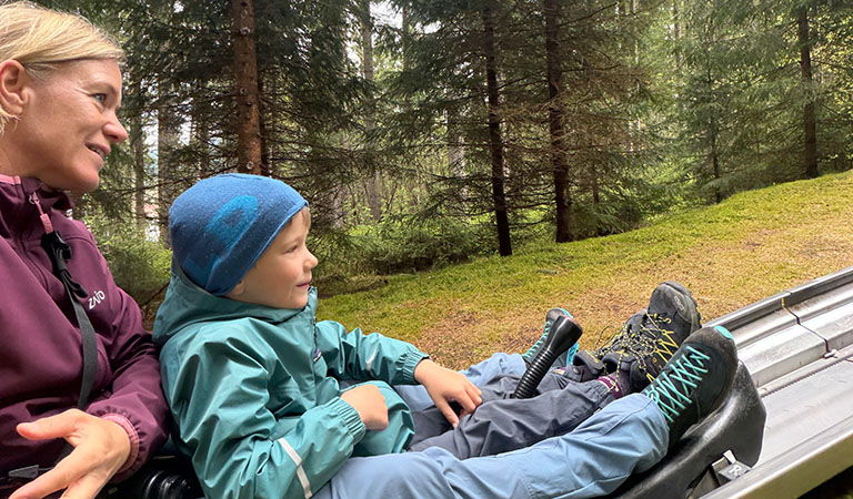 Mutter und Sohn in der Sommerrodelbahn von Harrachov im Riesengebirge in Tschechien.