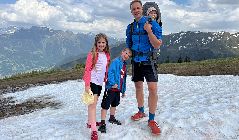 Familie auf einem schneebedeckten Gipfel im Sommer in Vorarlberg bei Montafon in Österreich.