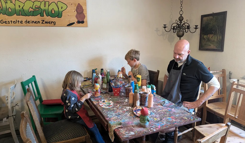 Kinder und Vater beim bemalen von Gartenzwergen im "Zwergshop" in Gräfenroda im Thüringer Wald.