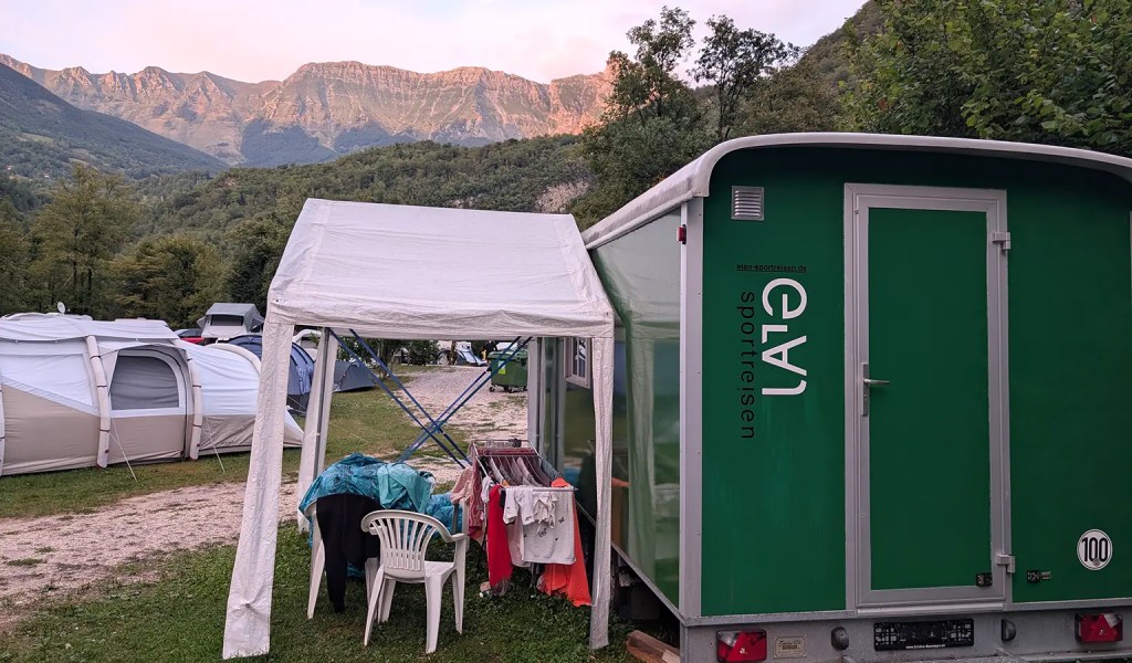 Bauwagen Familien-Sportcamp in Slowenien mit Bergpanorama im Hintergrund.
