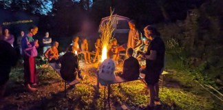 Familiencamp in Slowenien: Aktivurlaub mit Teenagern im Sočatal Eine Gruppe von Besuchern des Familien-Sportcamps von Elan Sportreisen in Slowenien sitzt am Lagerfeuer.
