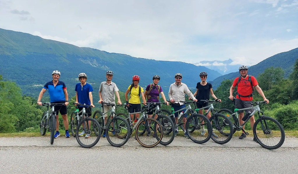 Eine Gruppe von Fahrradfahrern vor einem Bergpanorama im Triglav Nationalpark in Slowenien.