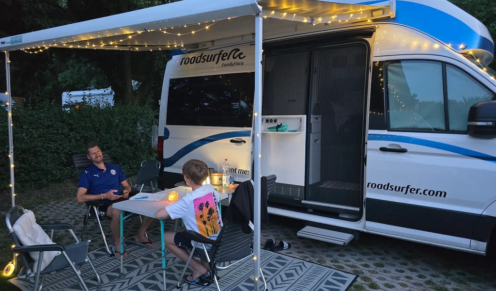Vater und Sohn vor dem Camper am letzten Abend in auf dem Campingplatz Zeeburg in Amsterdam.