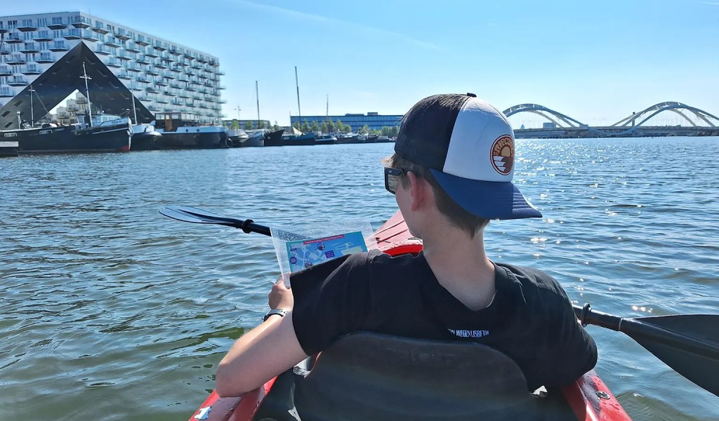 Ein Junge macht eine Kanufahrt in Amsterdam.