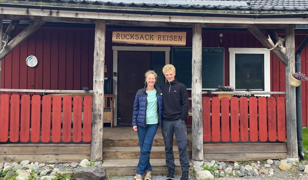 Mutter und Sohn vor der Rezeption des Rucksack-Reisen-Camps Idre Stugor in der schwedischen Provinz Dalarna.